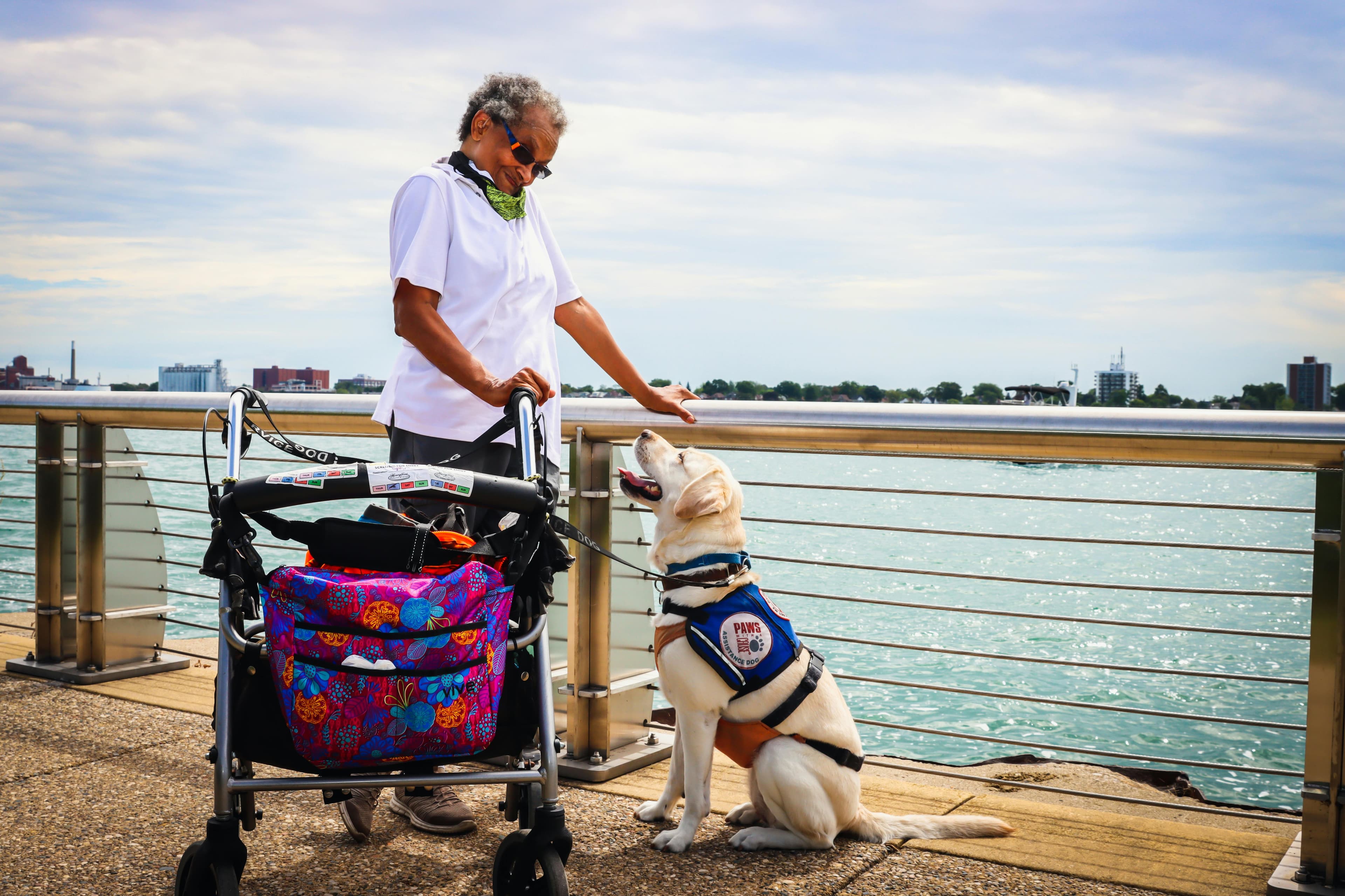 A senior woman enjoying a day by the water with her service dog